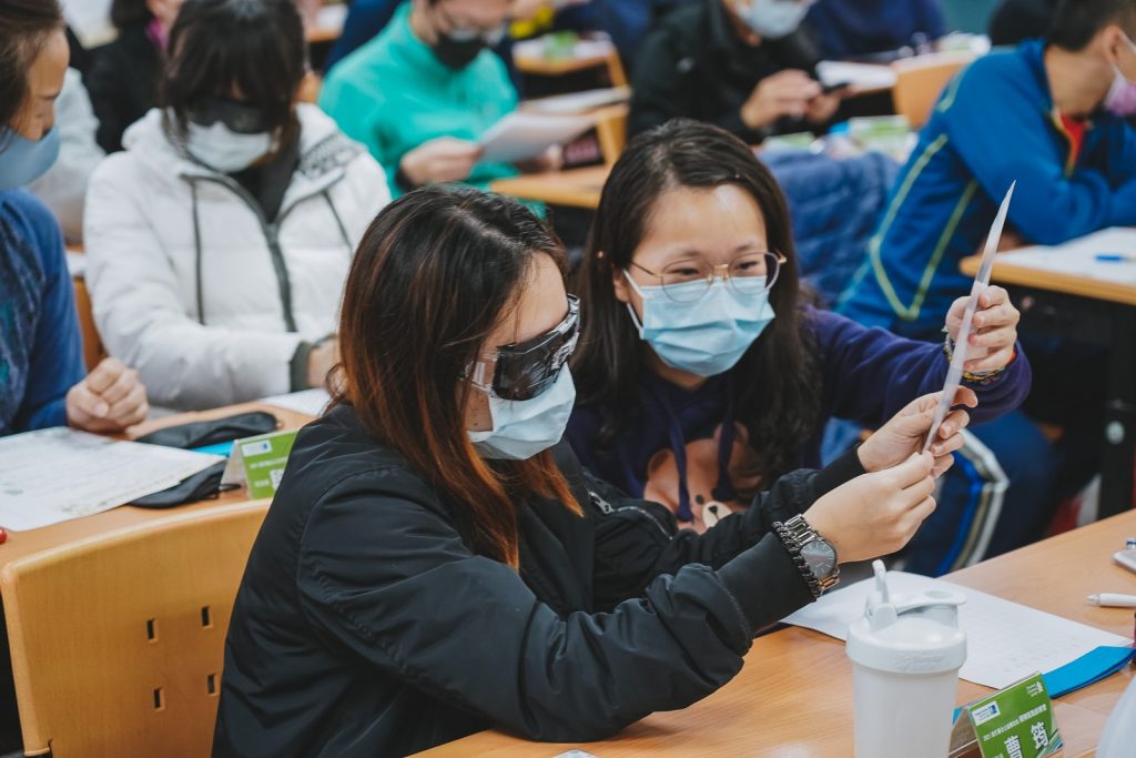 跑者戴上各式不同的眼鏡模擬視障者進行閱讀與書寫，實際感受視障者在生活上的種種不便利